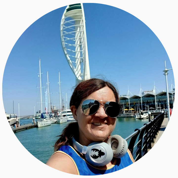 Lady smiling at the camera in front of boats.
